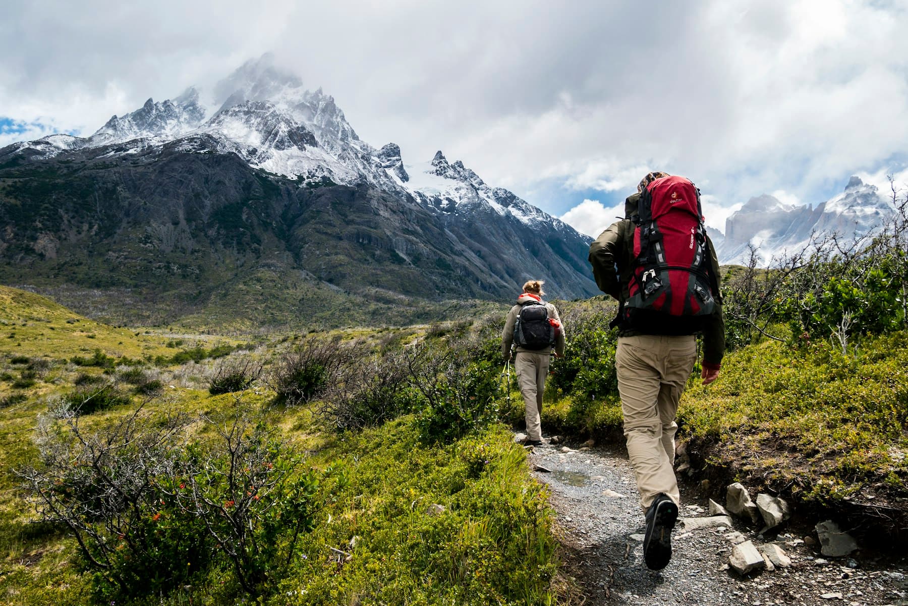Dois exploradores a caminhar num trilho de montanha